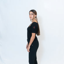 Load image into Gallery viewer, Deep scoop neck black t-shirt with Ari Arteaga&#39;s red heart on the left shoulder
