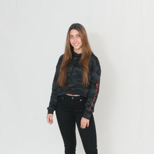 Load image into Gallery viewer, Stylish black camo print cropped hoodie with Be the Light written in red on the sleeve

